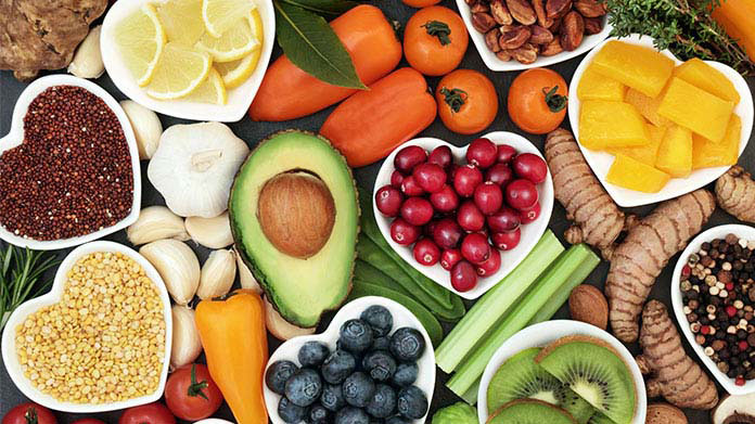 A variety of fruits and vegetables, some in heart-shaped bowls.