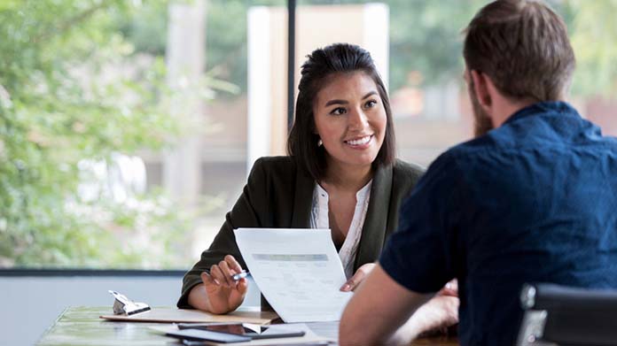 a woman holding a piece of paper and looking at a man